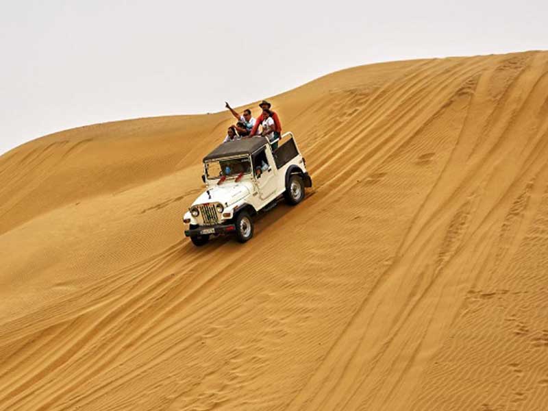 Jeep on a high sand dune